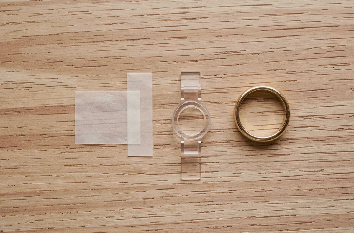 Flat lay des astuces maison pour empêcher une bague de tourner sur le doigt, sur une surface en bois clair
